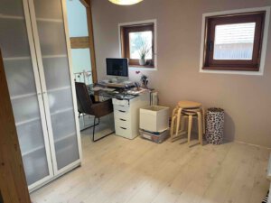 Homeoffice in einem Schwanau Architektenhaus mit Computertisch, weißem Kleiderschrank, gestapelten Hockern und hellem Boden