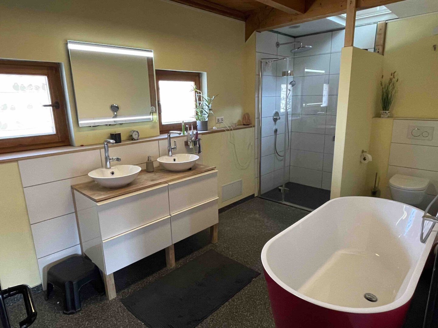 Modernes Schwanau-Badezimmer mit Doppelwaschbecken, ebenerdiger Dusche, freistehender Badewanne und viel Tageslicht in einer stilvollen Doppelhaushälfte